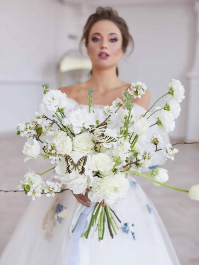 Bride with a white wedding bouquet of flowering cress, peony roses and resin at White Castle Studio in Beroun