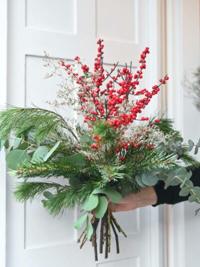 Vánoční kytice uvázaná z cesmíny, borovice, jedle a eukalyptu.