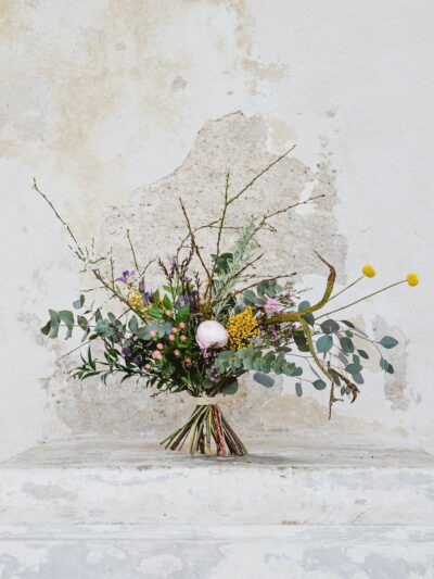 A seasonal bouquet with ranunculus, mimosa, craspedia, clematis, St. John's wort, eucalyptus, dried flax and willow twigs